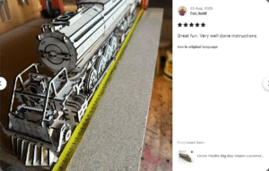 Petr measuring the length of the assembled laser cut train model.